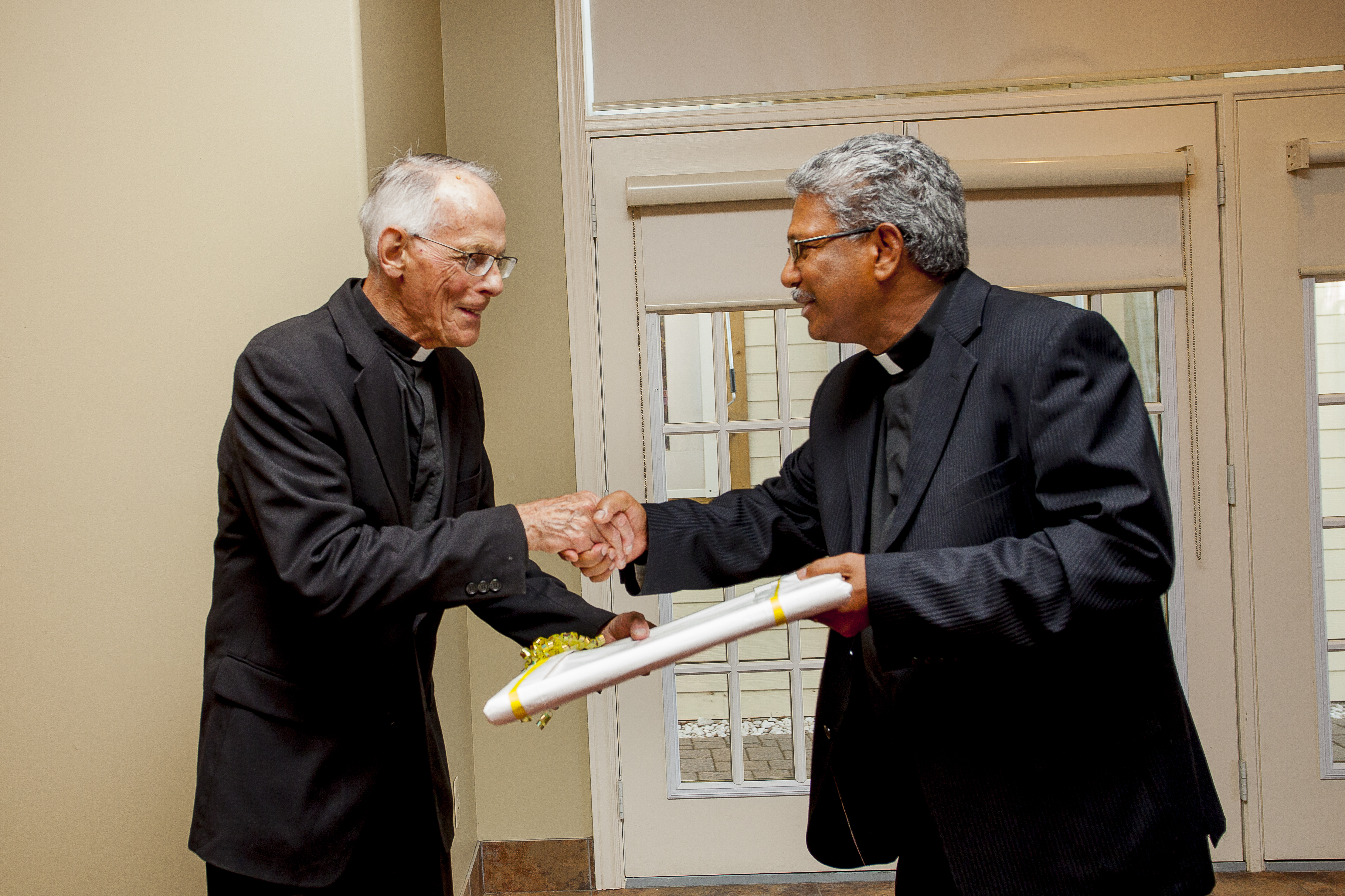 Fr. Joseph congratulates Msgr. John Pilkauskas on his 50th Ordination Anniversary and presents gift